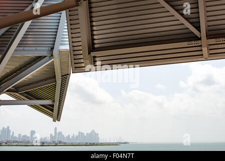 Biomuseo Frank Gehry architecture Panama City Skyline Pacific Ocean Panama | PANAMA CITY, Panama — la verrière en métal plié du Biomuseo encadre une vue brumeuse sur la baie de Panama vers le quartier financier de Panama City, vu de la chaussée Amador à l'entrée Pacifique du canal de Panama. L'architecte Frank Gehry a pris la commission en 2002 après avoir participé à des conférences de planification à la suite de la cession du canal au Panama en 1999 ; son épouse née au Panama, Berta Isabel Aguilera, a également participé à ce processus. Banque D'Images
