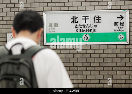 Un passager de métro de Tokyo se trouve en face d'un nom de la station de bord corrigée à Kita-senju gare le 7 août 2015, Tokyo, Japon. En juillet photos de Kita-senju station nom panneaux avec la mauvaise orthographe a circulé sur Internet à travers les médias sociaux. Le deuxième caractère kanji du nom était mauvais, ce qui signifie que le nom traduit les panneaux ''à sec du nord vivant'', plutôt que de ''north milliers vivant'' qu'ils auraient dû. Métro de Tokyo a commencé à corriger l'erreur sur le 29 juillet avec le caractère ''milliers'' remplacement ''dry'' dans tous les panneaux placés le long de la ligne Chiyoda plate-forme. Au métro de Tokyo Banque D'Images