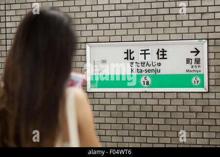 Un passager de métro de Tokyo se trouve en face d'un nom de la station de bord corrigée à Kita-senju gare le 7 août 2015, Tokyo, Japon. En juillet photos de Kita-senju station nom panneaux avec la mauvaise orthographe a circulé sur Internet à travers les médias sociaux. Le deuxième caractère kanji du nom était mauvais, ce qui signifie que le nom traduit les panneaux ''à sec du nord vivant'', plutôt que de ''north milliers vivant'' qu'ils auraient dû. Métro de Tokyo a commencé à corriger l'erreur sur le 29 juillet avec le caractère ''milliers'' remplacement ''dry'' dans tous les panneaux placés le long de la ligne Chiyoda plate-forme. Au métro de Tokyo Banque D'Images