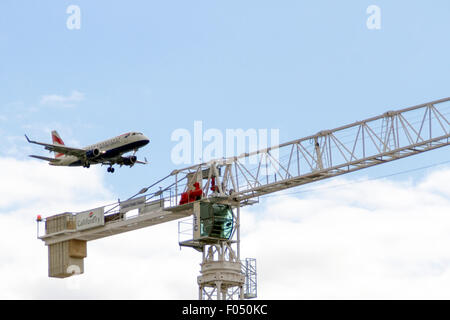 British Airways Airbus A318 à l'atterrissage à l'aéroport London City à grue derrière la tour de Gallions Reach, développement Docklands Banque D'Images