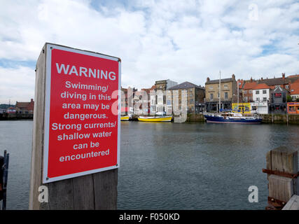 Signer un avertissement sur les dangers de la plongée le saut et la natation à Whitby Harbour quayside Banque D'Images