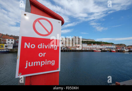 Signer un avertissement sur les dangers de la plongée le saut et la natation à Whitby Harbour quayside Banque D'Images