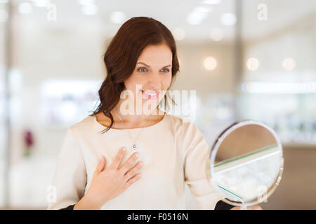 Happy woman choisir au magasin de bijoux pendentif Banque D'Images