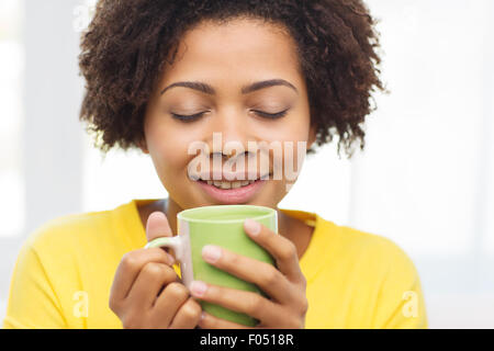 Happy african american woman à partir de la tasse de thé Banque D'Images