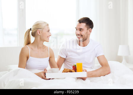 Heureux couple having breakfast in bed at home Banque D'Images