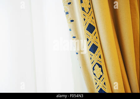 Rideau de fenêtre jaune élégant tourné contre la lumière extérieure Banque D'Images