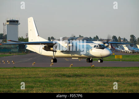 Hélice avion turbopropulseur blanc sur la piste à l'aéroport sur le coucher du soleil Banque D'Images