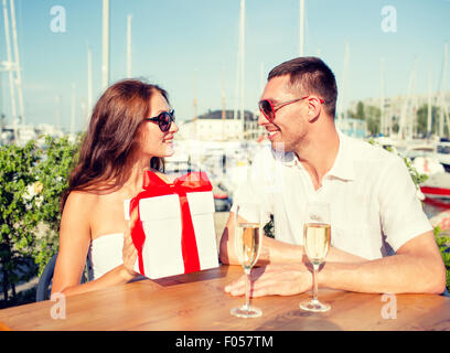 Smiling couple avec boîte-cadeau cafe Banque D'Images