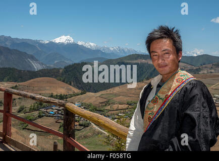 Un tibétain homme habillé en costume traditionnel pose devant de Meili Snow Mountain dans la province du Yunnan en Chine Banque D'Images