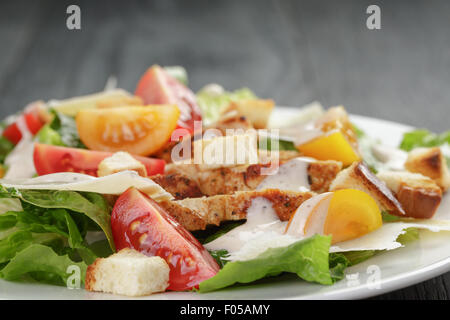 Salade césar avec poulet sur table en chêne Banque D'Images