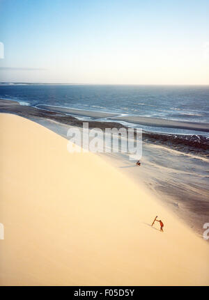 Un sable boarder rides une dune dune au coucher du soleil. Jericoacoara, Brésil Banque D'Images