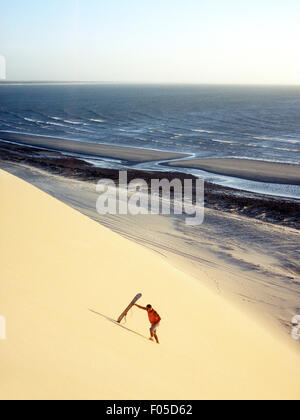 Un sable boarder randonnées sauvegarder une dune pour un autre tour au coucher du soleil Dune. Jericoacoara, Brésil . Banque D'Images