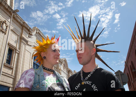 Two Punks with dyed Hair, Mohawk Liberty Spikes mohican hairstyle at Blackpool, Lancashire, Royaume-Uni.Août 2015.Festival Punk Rebellion aux jardins d'hiver.Un couple affronte les cultures de la célèbre ville balnéaire de Blackpool tandis que les punks participant au festival annuel de la rébellion dans les jardins d'hiver se côtoient avec les vacanciers traditionnels.Crédit : MediaWorldImages/Alamy Live News Banque D'Images