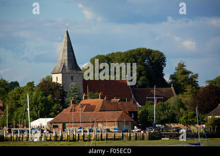 Vue sur le village de Sussex de l'Ouest Bosham. L'église du village et chaumières sont à côté de la vase à marée basse. Banque D'Images