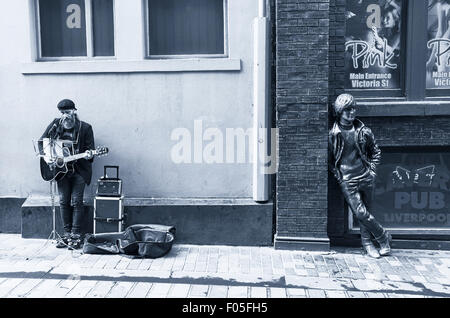 Musicien ambulant et statue de John Lennon à Liverpool Banque D'Images