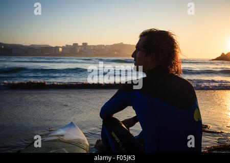 Pablo surfeur assis sur Macineira avec plage de surf. Plage Orzan. A Coruna. La Galice. L'Espagne. Banque D'Images