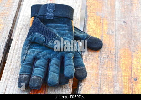 Paire de gants en cuir noir travailler sur une table en bois Banque D'Images