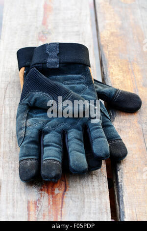 Paire de gants en cuir noir travailler sur une table en bois Banque D'Images