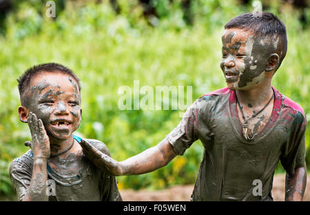 Hill tribe garçons jouant dans la boue à Chiang Mai, Thaïlande, Asie. Banque D'Images