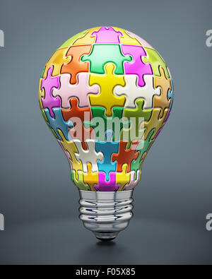 Pièces de puzzle colorées formant une ampoule électrique. Banque D'Images