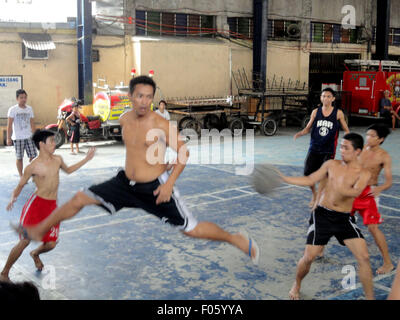 Quezon City, Philippines. Le 08 août, 2015. Un Philippin saute alors qu'il passe le ballon à un coéquipier d'empêcher le ballon de sortir du terrain pendant un match de basket-ball dans la banlieue. © Richard James Mendoza/Pacific Press/Alamy Live News Banque D'Images