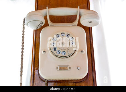Très vieux téléphone à cadran dans la paroi d'un train rétro. Banque D'Images