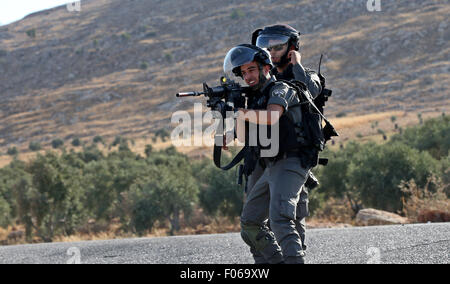 Douma, Cisjordanie, territoire palestinien. 8e août, 2015. Les forces de sécurité israéliennes prendre position au cours d'affrontements avec des manifestants palestiniens sur une rue menant au village de Douma, à une manifestation à la suite des funérailles de Saad Dawabsha, le père d'un enfant palestinien tué la semaine dernière lors de leur bombe incendiaire a été accueil par des extrémistes juifs, près de la ville cisjordanienne de Naplouse, le 8 août 2015. Credit : ZUMA Press, Inc./Alamy Live News Banque D'Images