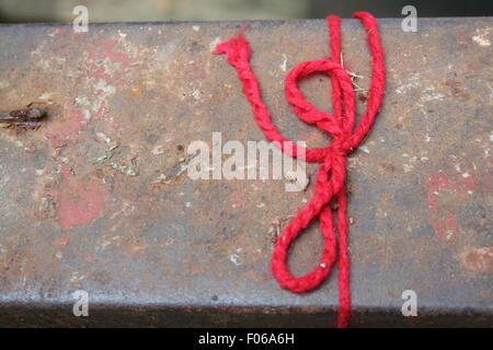 String rouge attaché sur un banc. Banque D'Images