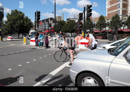 Cycliste sur piste en poussant sur un vieux routier de la rue au passage pour piétons de jonction de l'avant du trafic dans l'Est de Londres UK KATHY DEWITT Banque D'Images