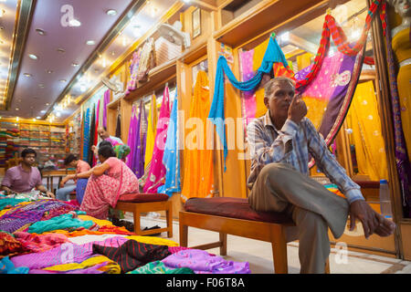 Un homme assis à l'intérieur d'un magasin de mode pour femmes à Jaipur, Rajasthan, Inde. Banque D'Images