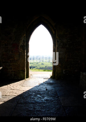Soleil qui brille à travers la porte voûtée, Tor de Glastonbury, Somerset, UK Banque D'Images