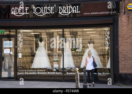 À la recherche d'une femme à travers la fenêtre à Robes de mariée dans une boutique sur high street Wolverhampton West Midlands, Royaume-Uni Banque D'Images