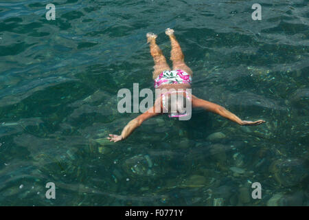 High angle view of senior woman que nager avec des lunettes dans la mer. Banque D'Images