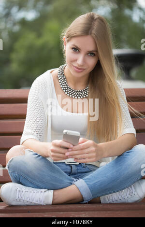 Femme professionnelle la lecture à l'aide de smart phone. Femme businesswoman reading news ou envoyer des textos sms sur smartphone tout en buvant du café sur pause du travail. Banque D'Images