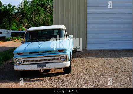 Un vieux camion Chevrolet des années 1960 se trouve à côté d'un pole barn in rural Moab, Utah. Banque D'Images