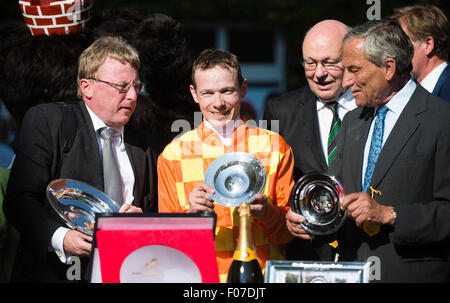 Craig Bennett (L-R), propriétaire de l'école d'Joyeux Fox Stud Limited, Gerhard Schoening, propriétaire de l'hippodrome de Hoppegarten, jockey Jamie Spencer, Walter Momper, ancien maire de Berlin, et l'entraîneur Matteo Luca Cumani célèbrent la victoire de Spencer à l'événement de course de chevaux Grand Prix de Berlin à l'hippodrome de Hoppegarten, Allemagne, 09 août 2015. Photo : GREGOR FISCHER/dpa Banque D'Images