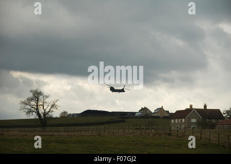 Un hélicoptère Chinook dans la formation de l'armée survole la campagne du Dorset en Angleterre sur une vieille journée d'hiver Banque D'Images