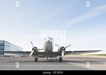 Image d'un petit avion d'argent à deux hélices stationné dans un aéroport lors d'une journée ensoleillée Banque D'Images