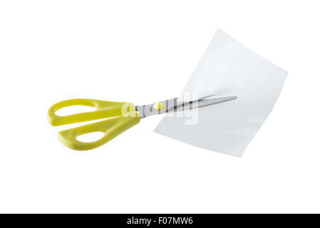 Une paire de ciseaux jaune couper un morceau de papier blanc isolé sur fond blanc. Banque D'Images