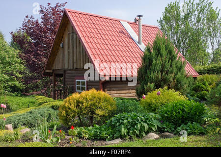 Pas de nom standard rural en bois hangar avec toit en tuiles rouges dans le jardin décoratif européen du paysage. Journée ensoleillée Banque D'Images