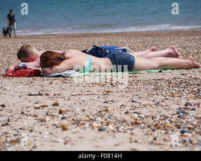 Un jeune couple en train de bronzer sur la plage Banque D'Images