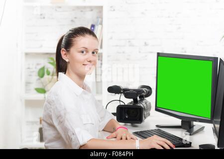 Jolie jeune femme éditeur vidéo avec écran vert Banque D'Images