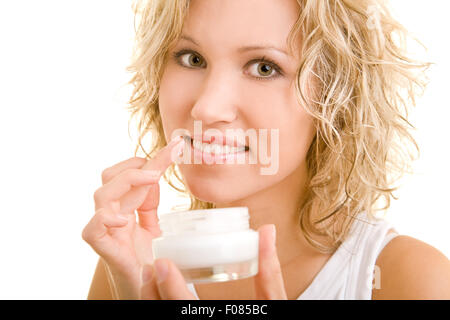 Jeune blonde woman putting lotion sur ses lèvres Banque D'Images