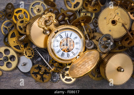Montre de poche et une sélection de pièces d'horloge en laiton vieux poussiéreux. Banque D'Images