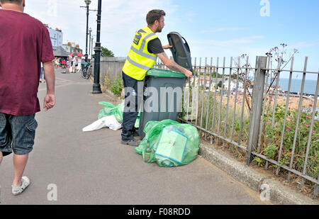 Broadstairs, Kent, Angleterre, Royaume-Uni. Homme vidange d'un bac de litière sur le front de mer Banque D'Images