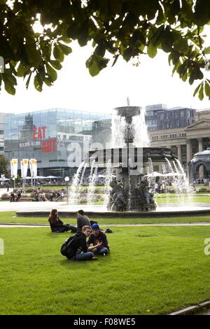 Les gens assis près de springrunnen à Schlossplatz à Stuttgart, Bade-Wurtemberg, Allemagne Banque D'Images