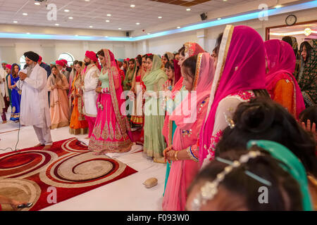 Prêtre avec mariés à Cérémonie de mariage Sikh Gurdwara Brant dans Londres Banque D'Images