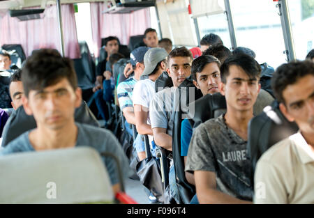 Passau, Allemagne. 10 août, 2015. Réfugiés de l'Afghanistan d'attendre dans un bus de la Police Fédérale Allemande à l'enregistrement de l'office des réfugiés à Passau, Allemagne, 10 août 2015. L'afflux de réfugiés a entraîné des conditions chaotiques à l'office fédéral de la police de Passau, avec les réfugiés pris en charge par la police d'être obligés de subir, chaud ou orageux pluvieux pendant qu'ils attendent à l'extérieur ou dans des abris de fortune pendant des heures. Photo : SVEN HOPPE/dpa/Alamy Live News Banque D'Images