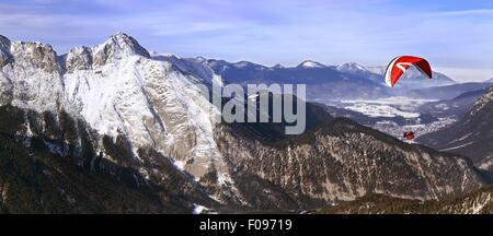 Homme parachute entre les montagnes de neige à Leutaschtal, Tyrol du Nord, Italie Banque D'Images