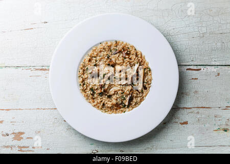 Risotto aux champignons sauvages cep boletus sur plaque blanche sur fond de bois bleu Banque D'Images